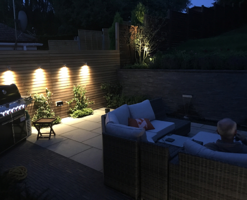 A contemporary granite patio and retaining wall with lighting