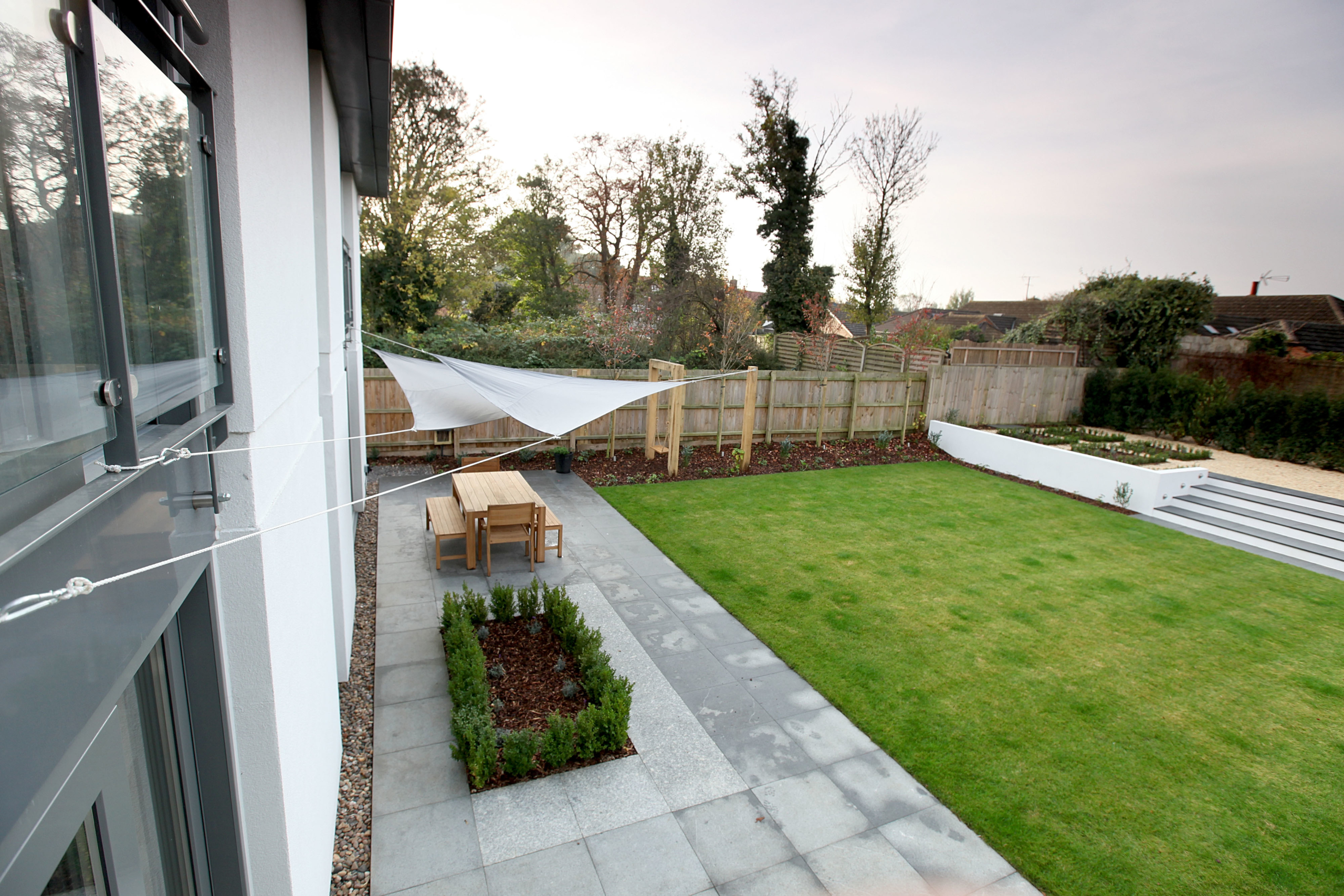 Large garden with patio, shaded seating, lawn and steps