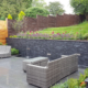 Medium modern garden patio with retaining wall