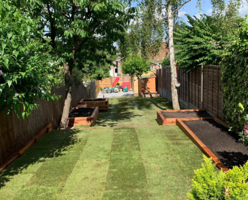 Medium traditional garden with lawn and raised beds