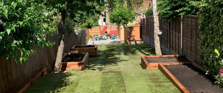 Medium traditional garden with lawn and raised beds