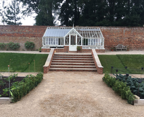 Greenhouse and steps in a large walled kitchen garden