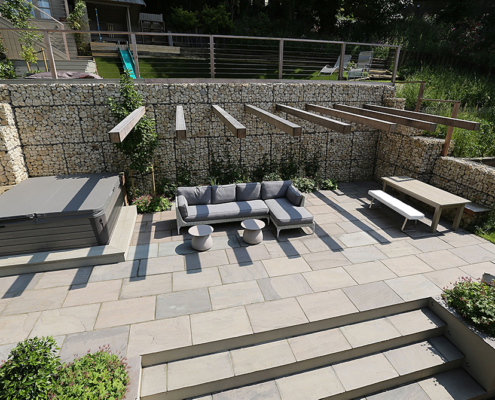 A large contemporary multilevel garden seating area and hot tub