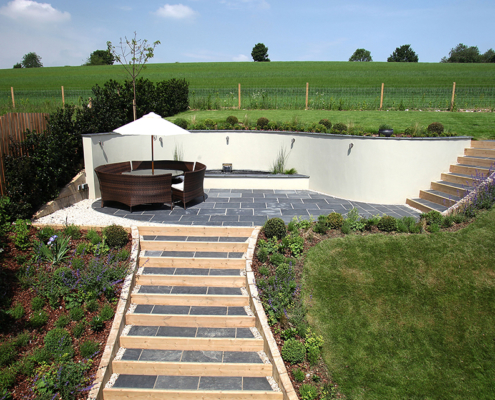 A sunken seating area with curved retaining wall and steps